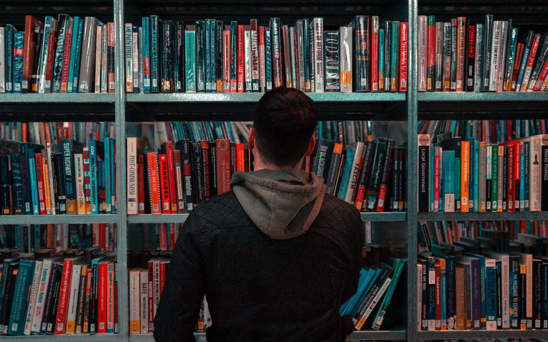 Mann vor Buchregal